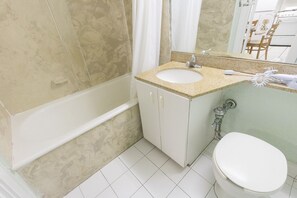 A bathroom with a white sink, a toilet, and a bathtub.