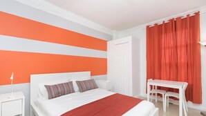 Una camera da letto con un letto, un comodino e una scrivania con sedie.