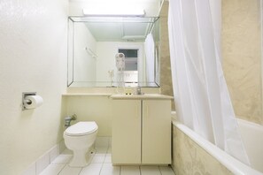 Ein Badezimmer mit Toilette, Waschbecken, Spiegel und Duschvorhang.