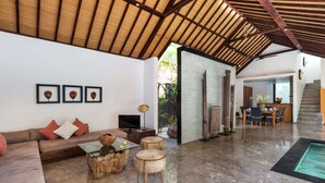 A spacious living area with a high ceiling, a sofa, a glass coffee table, and a dining area with a table and chairs. - Beautiful Villa with Private Pool, Bali Villa 2028 (Bali)