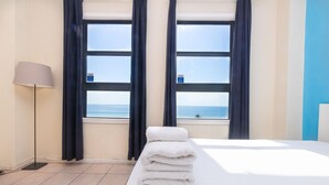 A hotel room with a bed, a lamp, and a view of the sea through large windows. - 764 Ocean View Hollywood Beach (Hollywood)