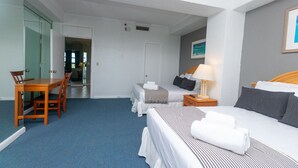 A hotel room with a bed, a desk, and a chair. There is a door leading to a bathroom. - 660 Ocean View Hollywood (Hollywood)