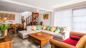 A living room with a sofa, coffee table, and a staircase leading to an upper level.
