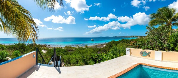 A pool area with a view of the ocean and a boat in the distance. - Crown Ridge 1, Oceanfront Villa, Direct Ocean Access, Private Pool (Kralendijk)