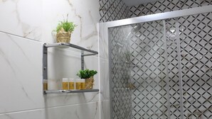 A bathroom with a shower enclosure featuring a diamond-patterned glass door. - Hostal Emperador (Merida)