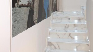 A staircase with marble steps and a column. - Hostal Emperador (Merida)