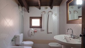 Un baño con inodoro, lavabo y ventana.
