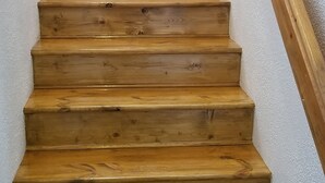 A wooden staircase with a handrail, leading up to a landing.