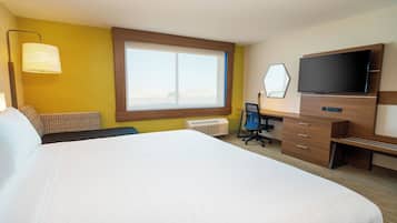 Habitación de hotel con una cama grande, un escritorio con silla, un televisor de pantalla plana y una ventana con persianas.