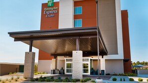 A Holiday Inn Express & Suites building with a modern design, featuring a covered entrance and a prominent number '175' on the facade.