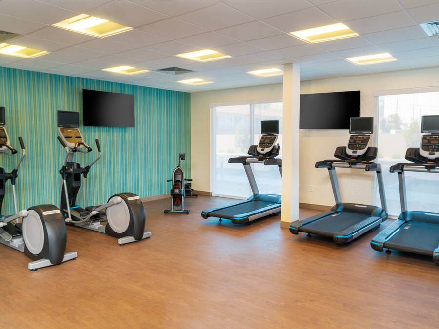 Una palestra con tapis roulant, ellittiche e cyclette.