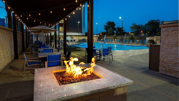 An outdoor pool area with lounge chairs and a fire feature.