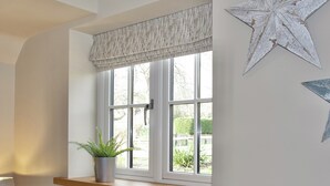 A window with a white valance, a potted plant on the sill, and a star decoration on the wall.