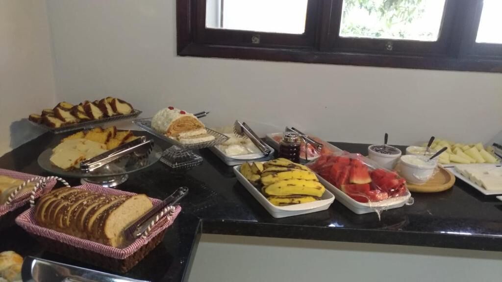 Un bufé con diversos alimentos, como pan, plátanos y un postre.