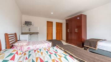 Une chambre avec un lit, un bureau et une armoire.