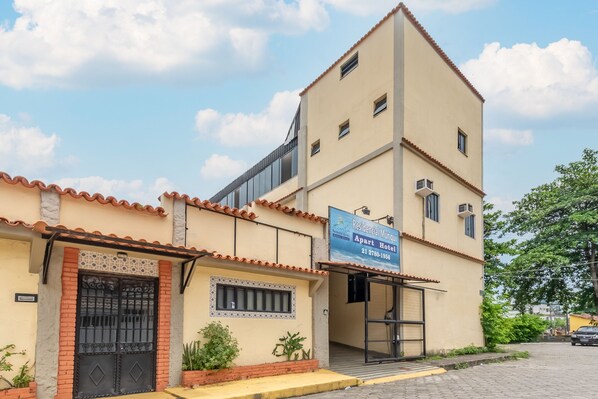 Un edificio de dos pisos con un letrero que indica que es un hotel-apartamento.