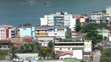 A coastal urban area with multi-story buildings, a visible road, and boats on the water.