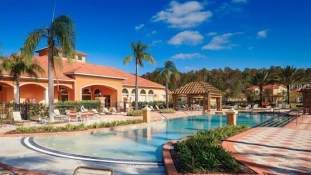 A resort with a swimming pool, palm trees, and a gazebo. - Bella Vida Resort Luxury Pool Home Game Room View! (Kissimmee)