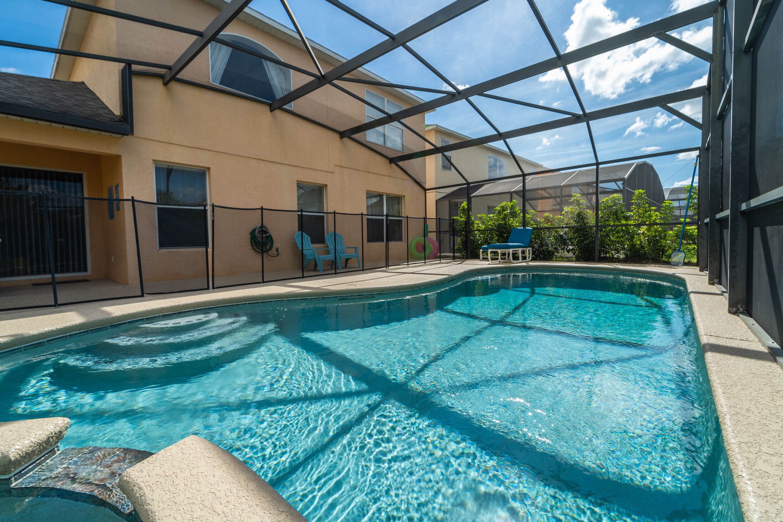 An indoor swimming pool with a clear view of the surrounding buildings and a covered patio area.