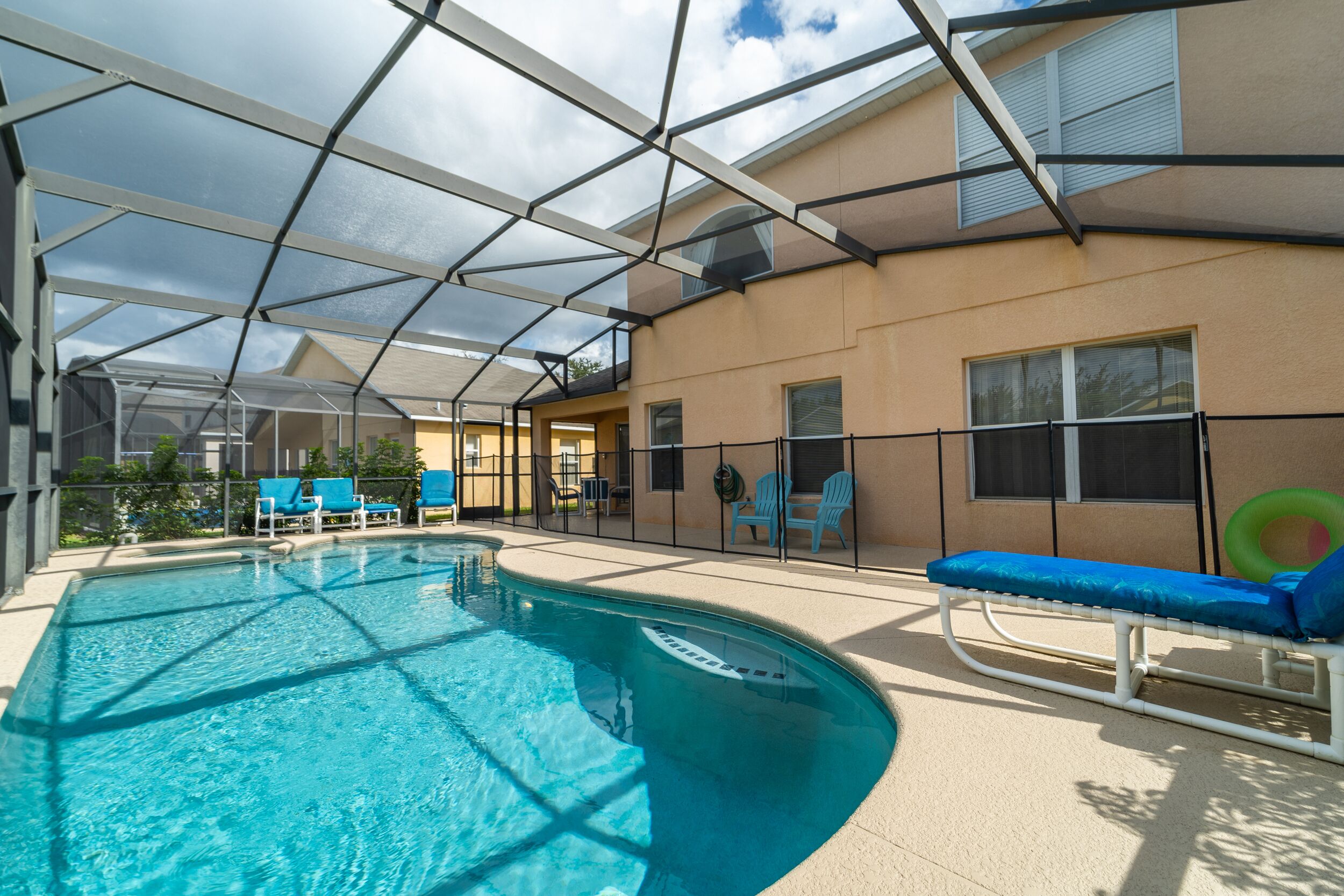 A covered swimming pool with lounge chairs and a sunbed.