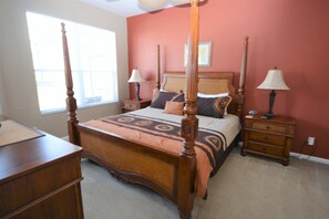Ein Schlafzimmer mit einem Himmelbett, zwei Nachttischen und einem Fenster.