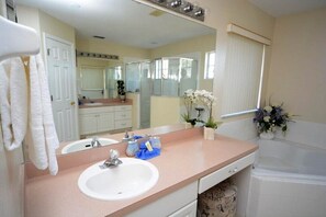 A bathroom with two sinks, a large mirror, a bathtub, and a window with blinds. - 86340 2-story Pristine 4-bed Pool Home W/hot Tub & Balcony (Kissimmee)