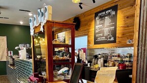 A coffee shop interior with a wooden counter, seating area, and a menu board.