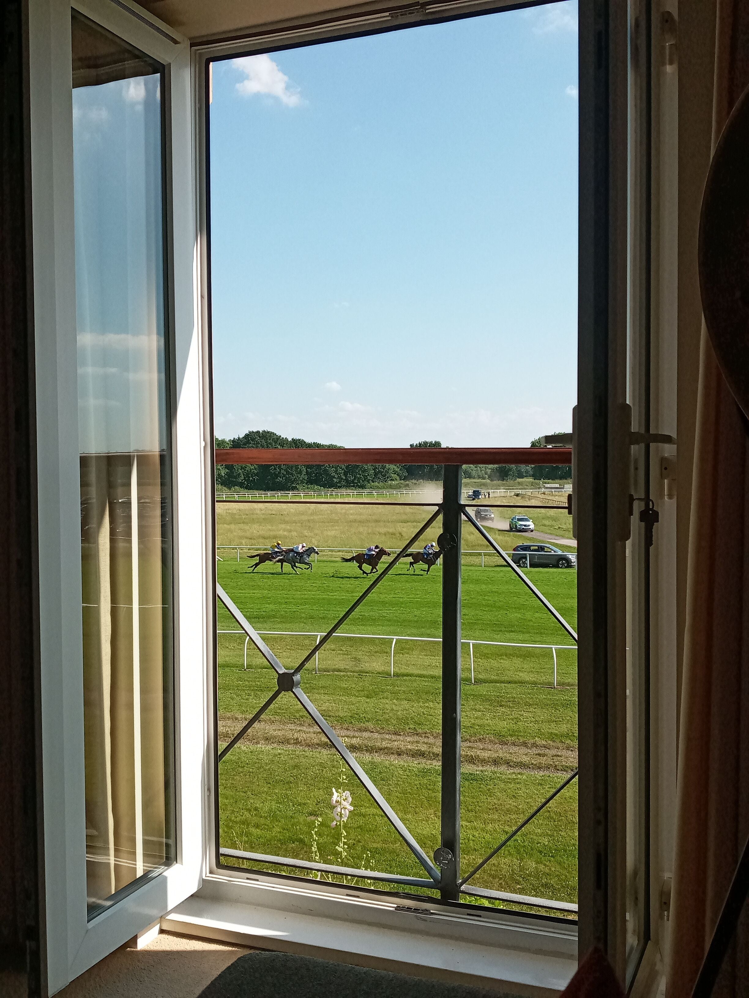 A view through a window of a horse race track with a clear sky.