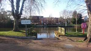 A sign reading "FERRY" near a body of water with a bridge, trees, and buildings in the background. - 47 Wetherby Way (Stratford-upon-Avon)