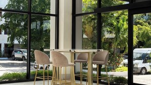 Un interior moderno con ventanas amplias, una mesa con sillas y lámparas esféricas colgantes.