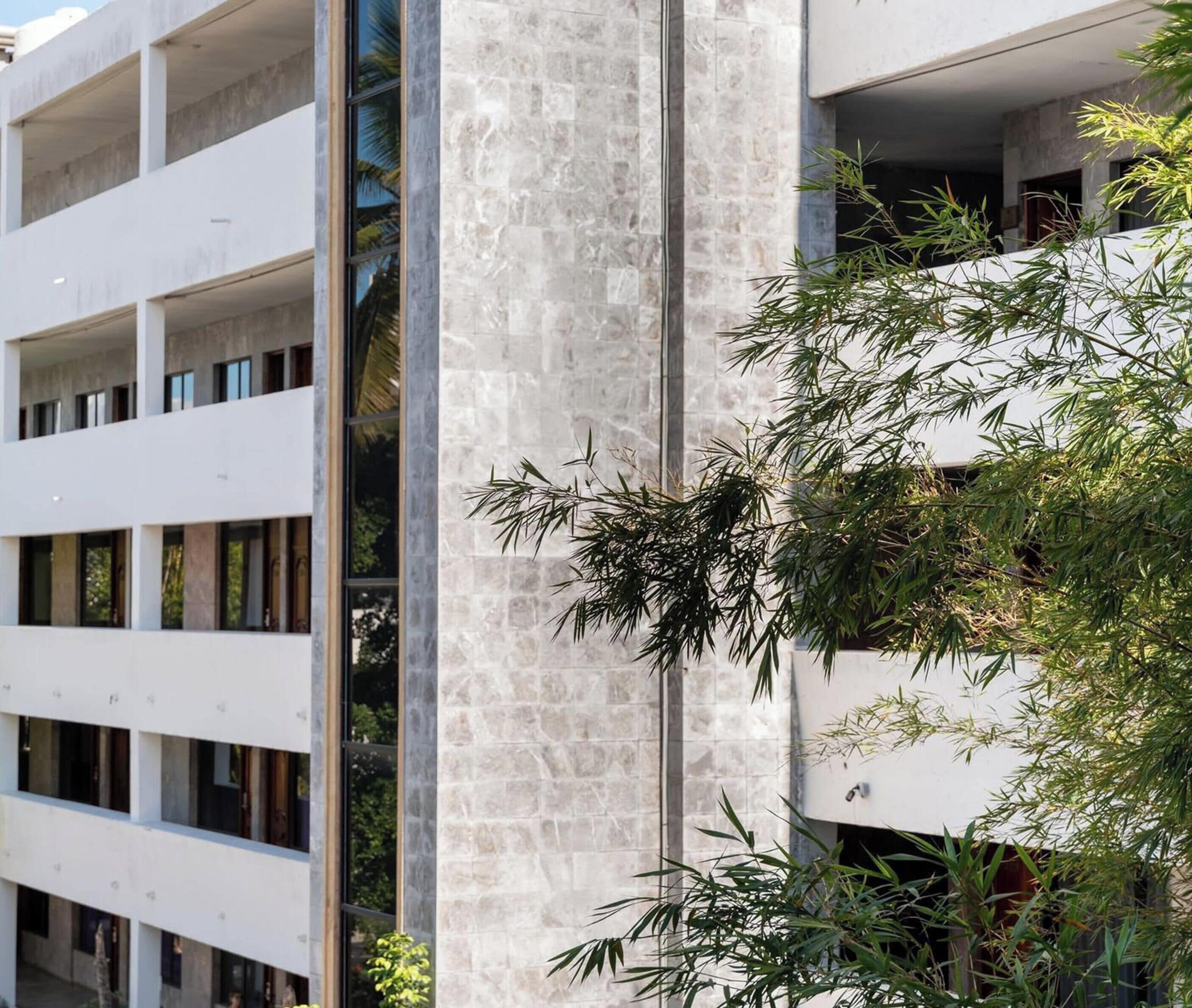 A multi-story building with a modern architectural style, featuring a combination of glass and stone facades.