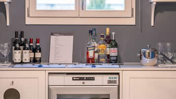 Un espace bar avec différentes bouteilles d’alcool, un menu et un lave-vaisselle.