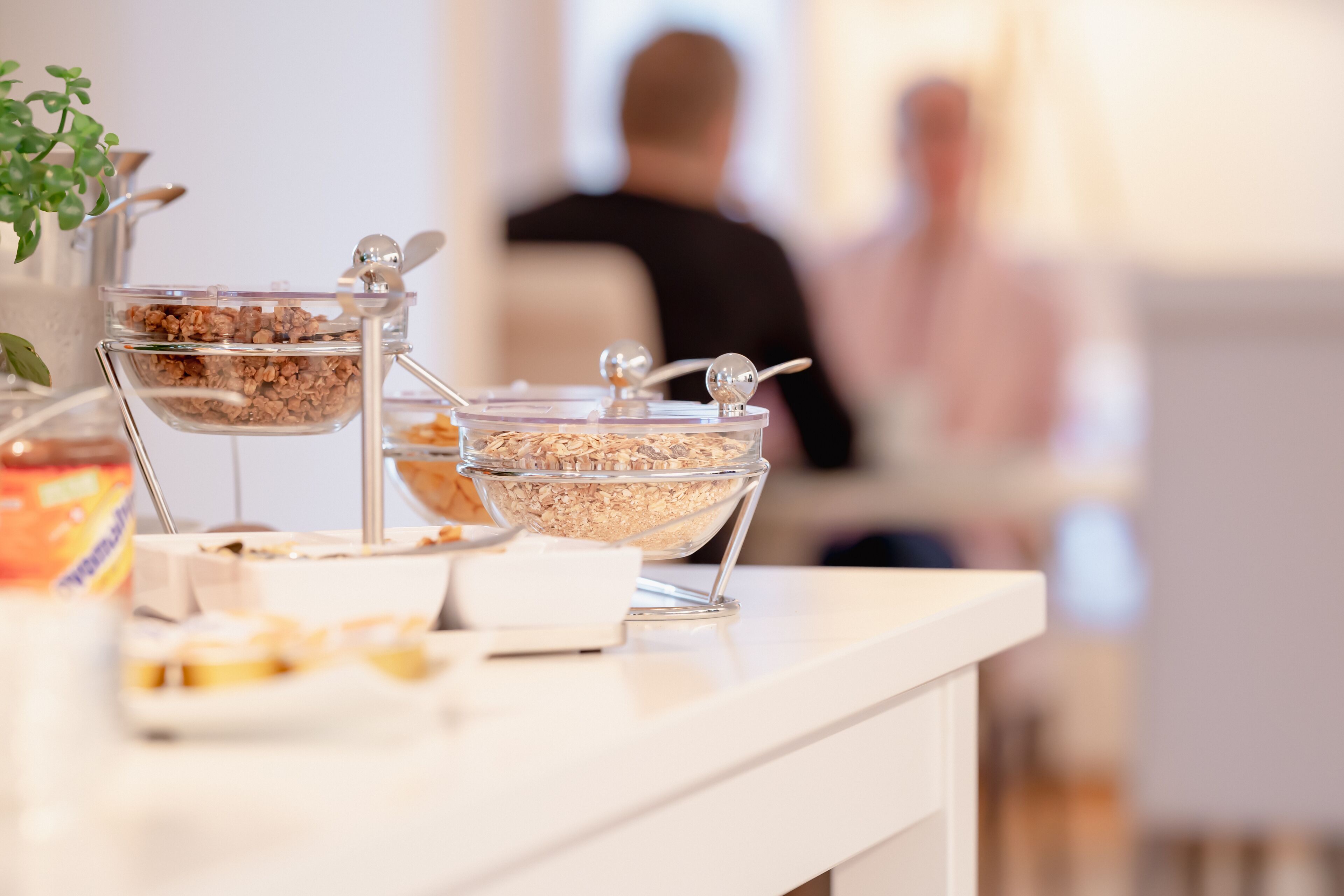 Una mesa de buffet con diversos alimentos en recipientes transparentes.