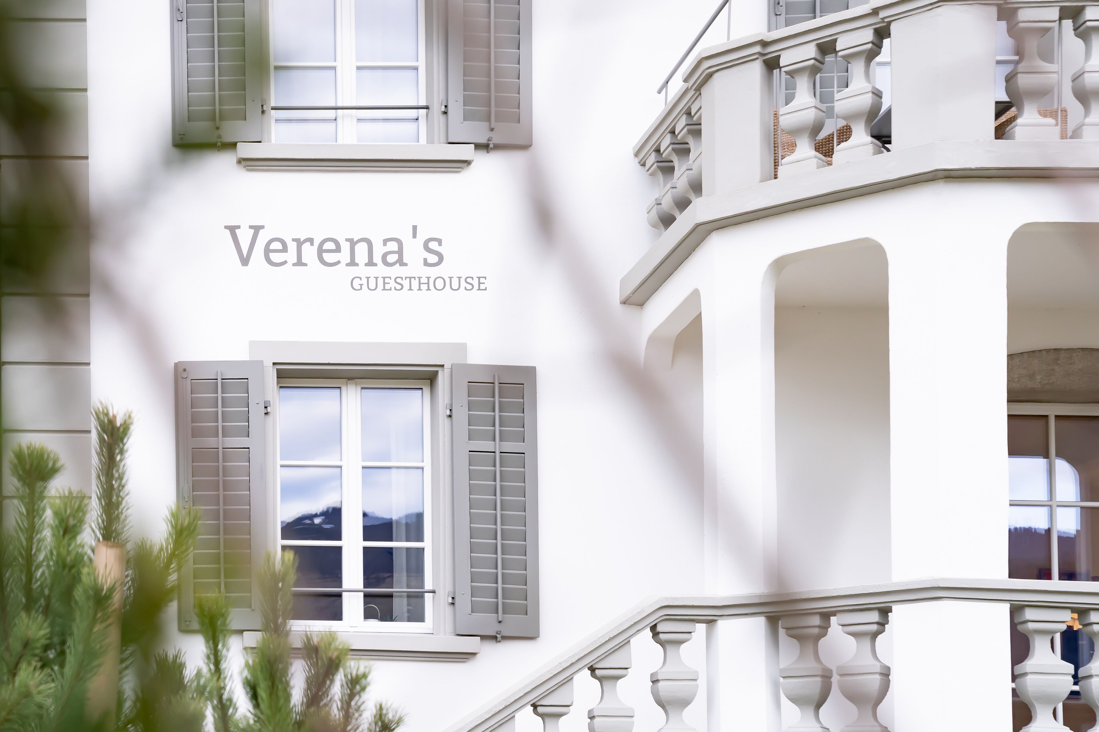 Un edificio blanco con el texto "Verena's Guesthouse" en la fachada.