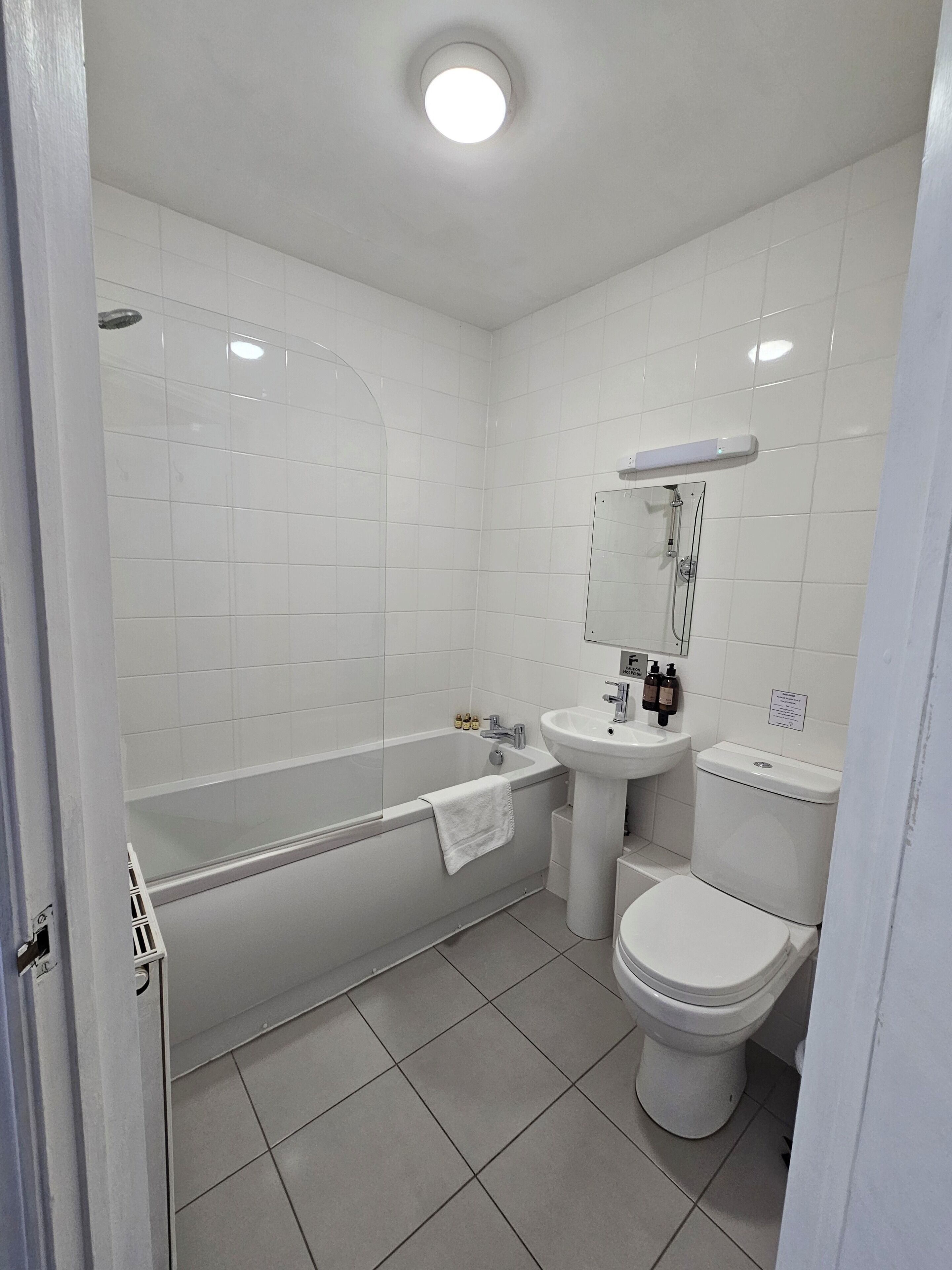 A modern bathroom with a bathtub, sink, and toilet.