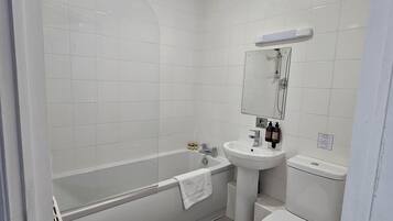 A modern bathroom with a bathtub, sink, and toilet.