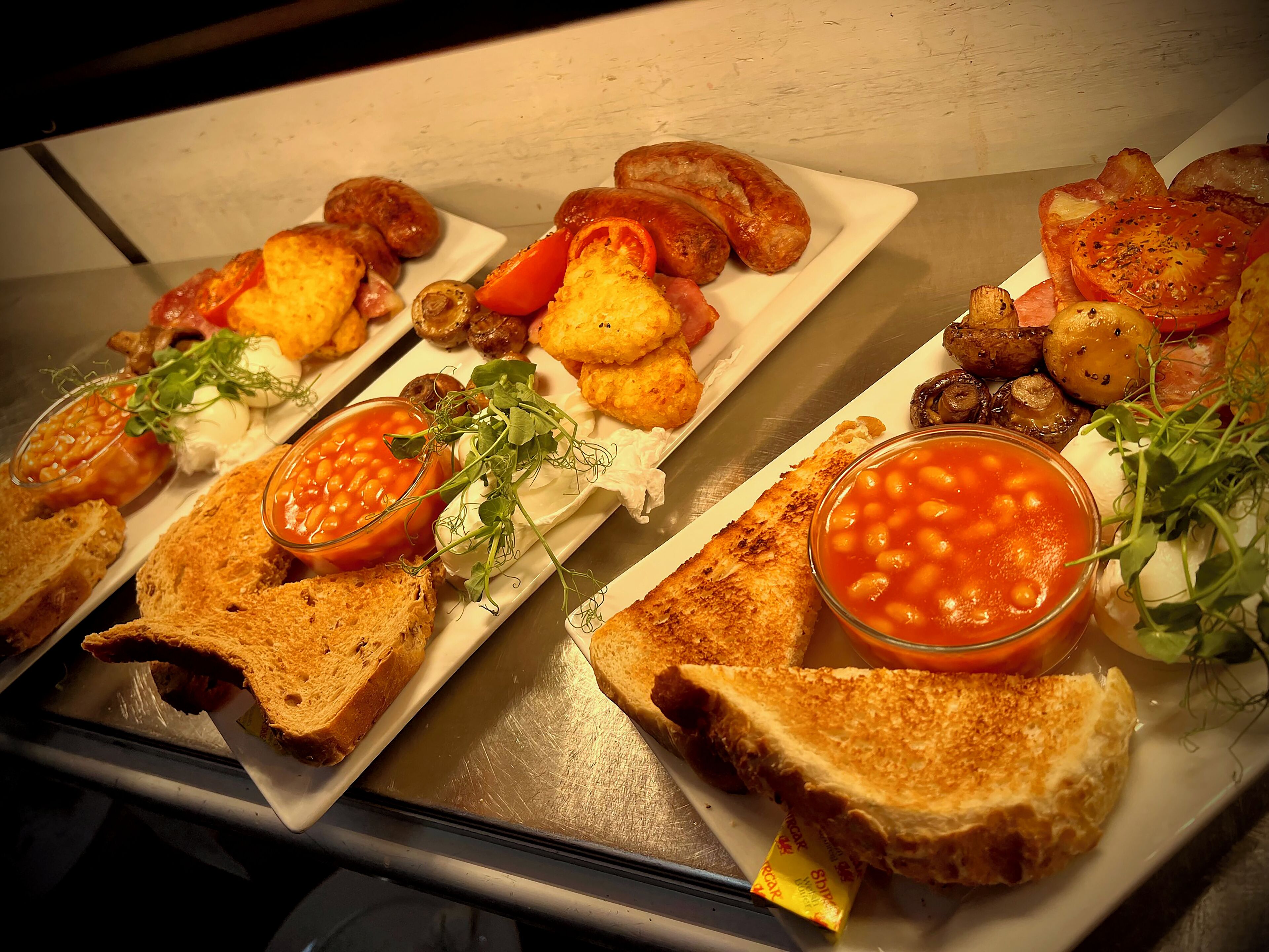 A variety of dishes including grilled sandwiches, roasted potatoes, and beans on toast.