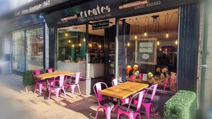 An outdoor seating area with tables and chairs in front of a café named 'Create'. - Creates (Monmouth)