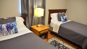 A hotel room with two single beds, a nightstand with a lamp, and a patterned rug. - 2BA 6-Beds 10-min to downtown Nashville! (Nashville)