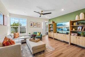 A modern living room with a sofa, coffee table, and a TV on a wooden cabinet.