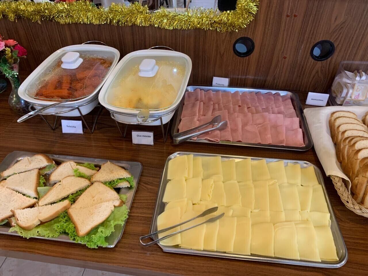Un buffet proposant une variété d’aliments, notamment des sandwichs, du fromage et de la charcuterie.