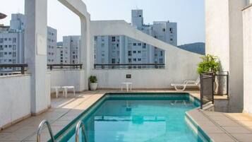 Una piscina al aire libre, sillones reclinables de piscina