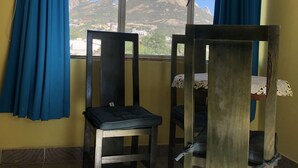 Una habitación con ventana, una silla y una cama litera.