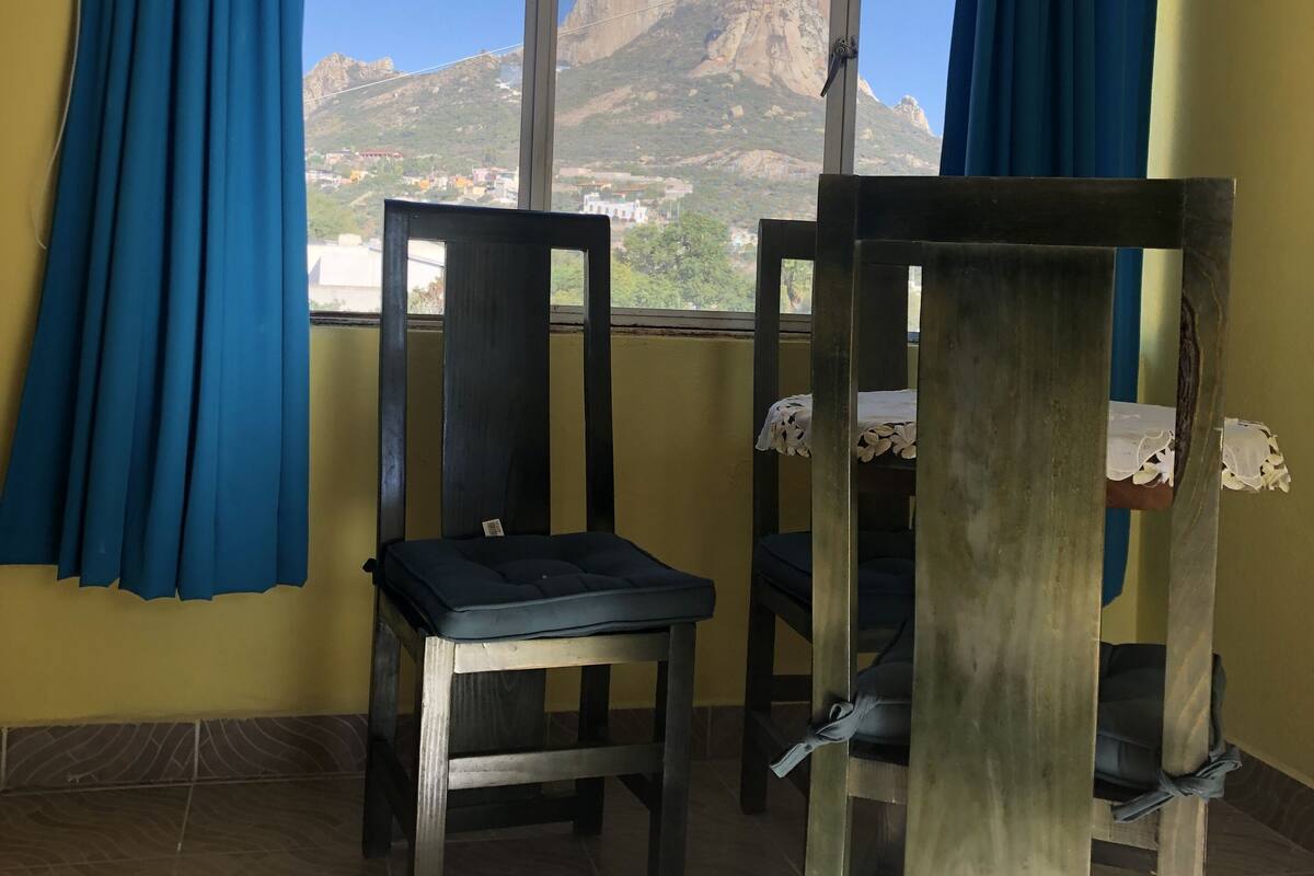 Una habitación con ventana, una silla y una cama litera.