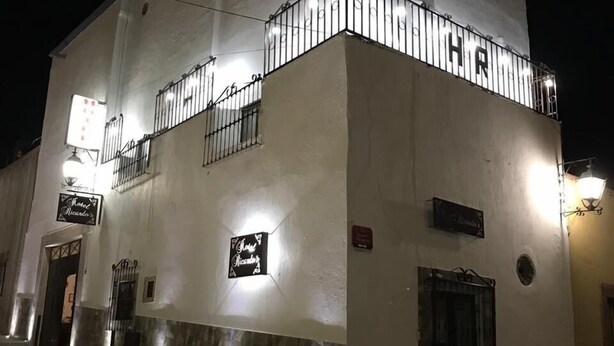 Un edificio blanco con un balcón y un letrero que dice "Hotel Ricardo".