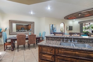Enjoy cooking in the well-equipped kitchen with a sink and wooden cabinets.