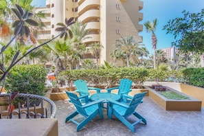 Relax in style on this serene patio surrounded by lush greenery and comfortable lounge seating.
