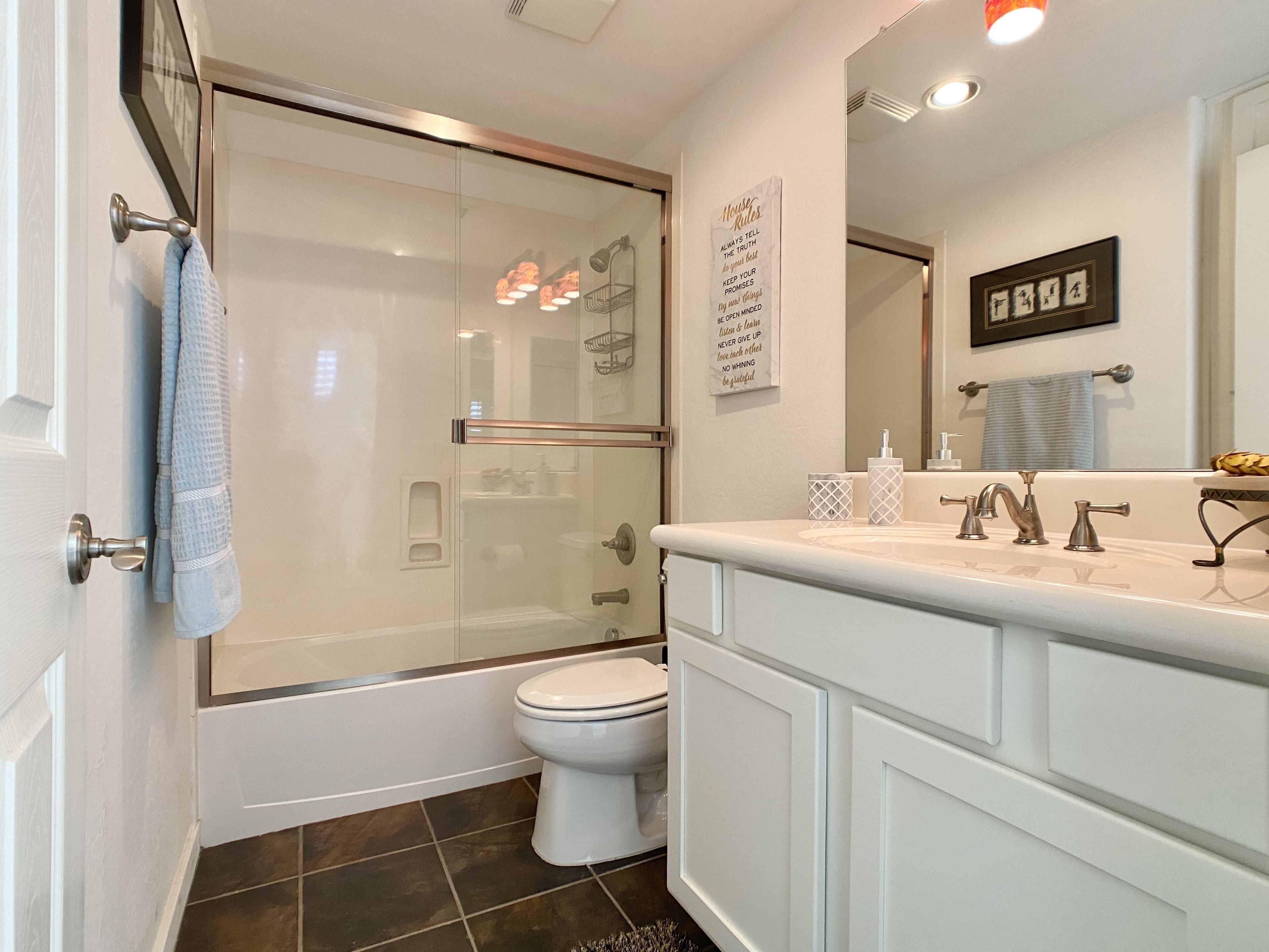 A modern bathroom with a glass shower enclosure, a white toilet, and a vanity with a mirror.
