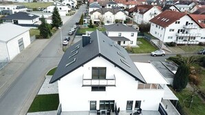 Un edificio moderno de dos pisos con techo plano y ventanas amplias.