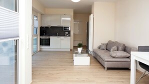 Un apartamento moderno con cocina, sala de estar y una mesa de comedor.
